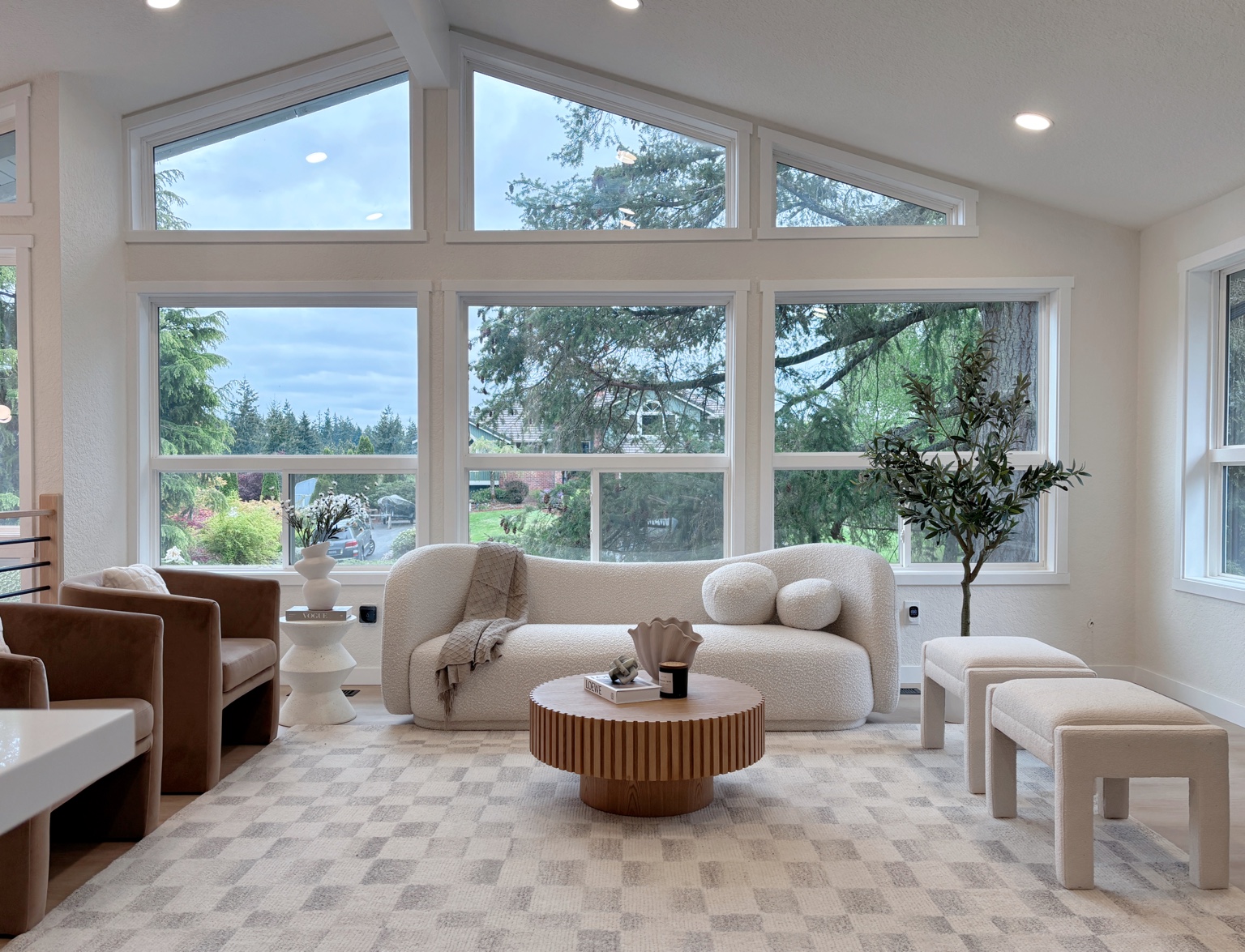 72F Home Design staged living room with a curved cream sofa, warm wood coffee table, and expansive windows