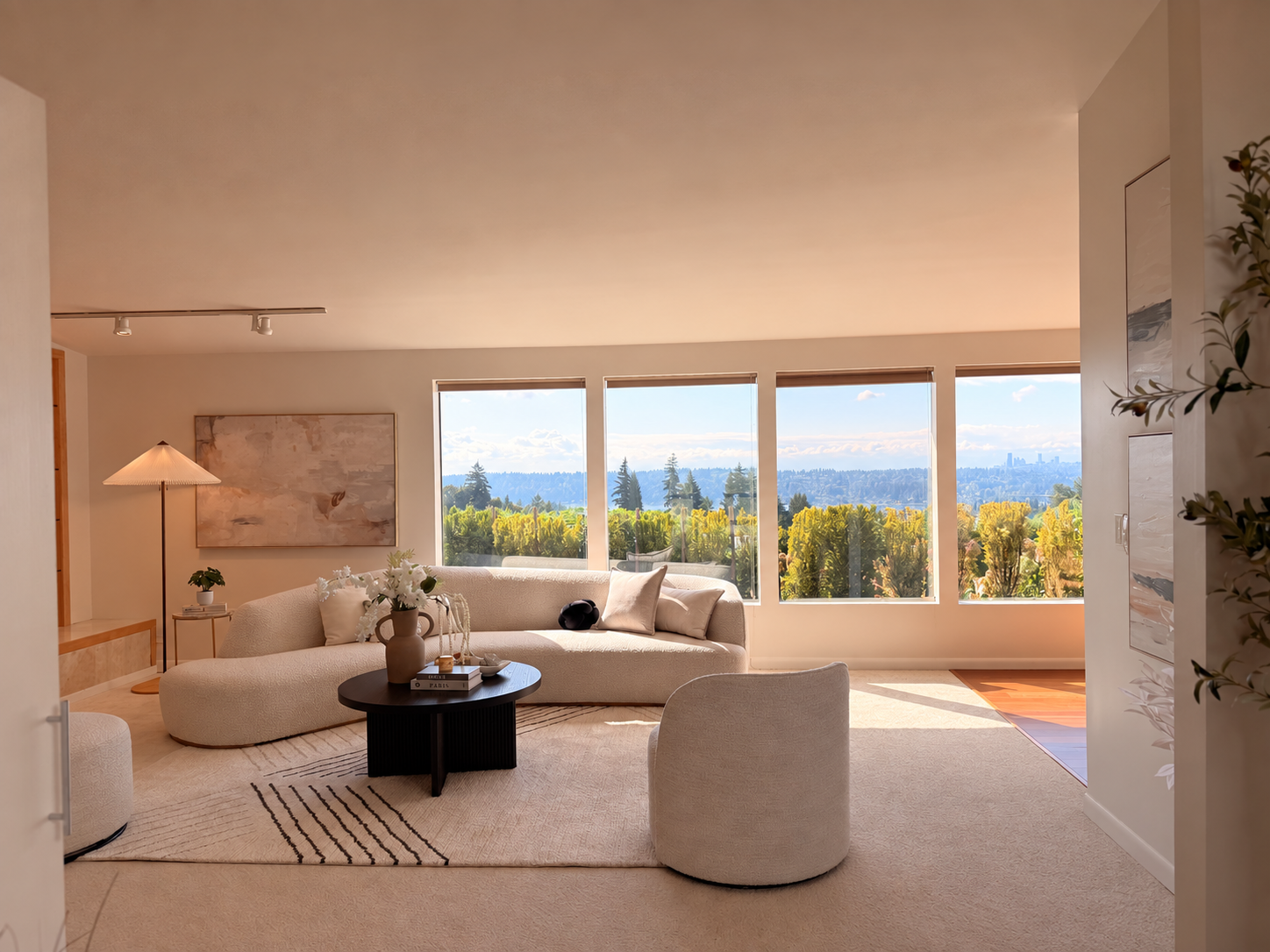 Sunlit living room with curved sofa and expansive windows