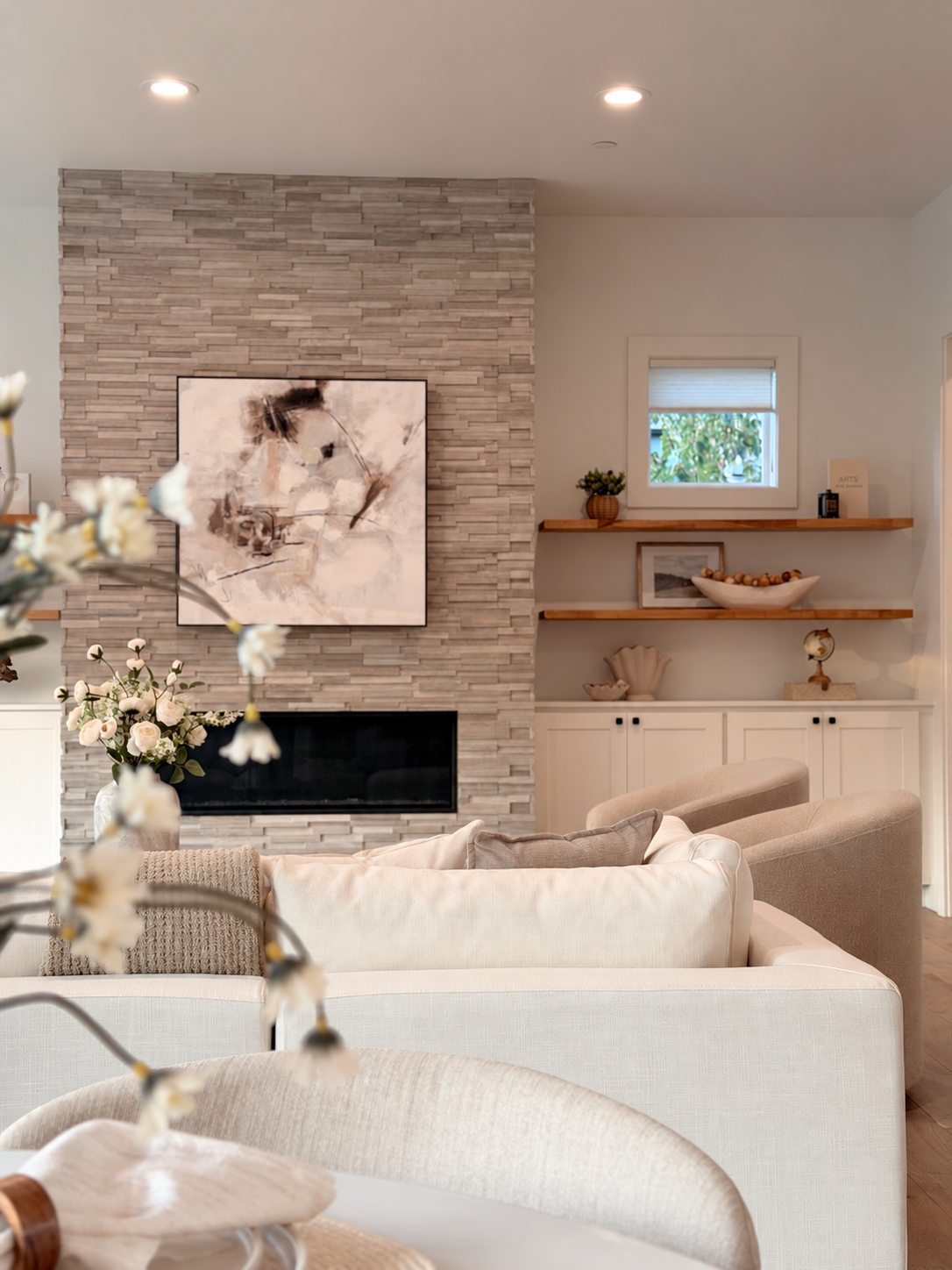 Living room with fireplace, artwork, and built-in shelves