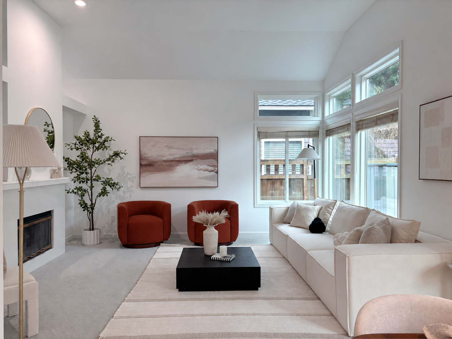 Living room with tall windows, white sofa, and rust chairs