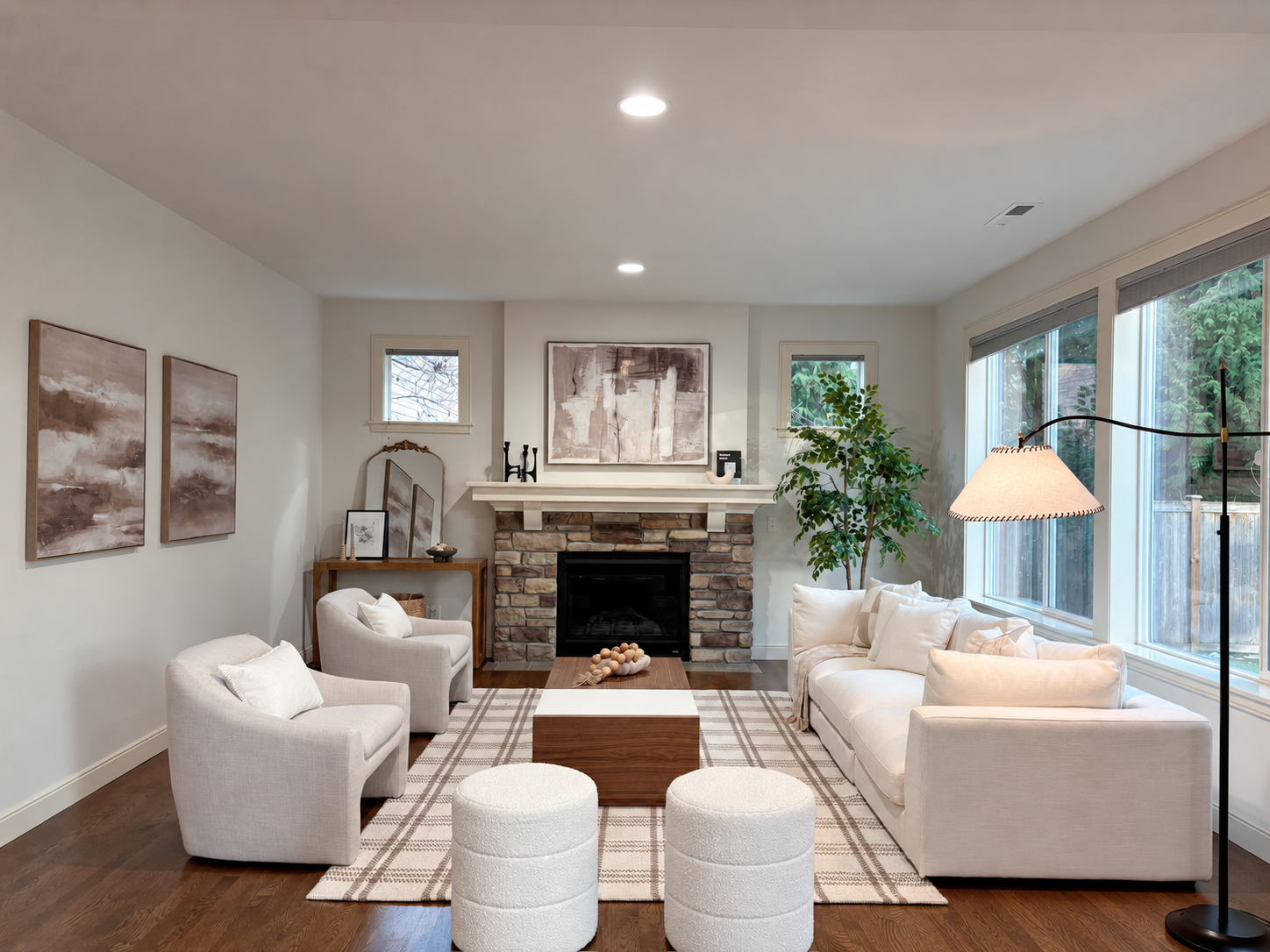 Warm staged living room with stone fireplace and cream seating